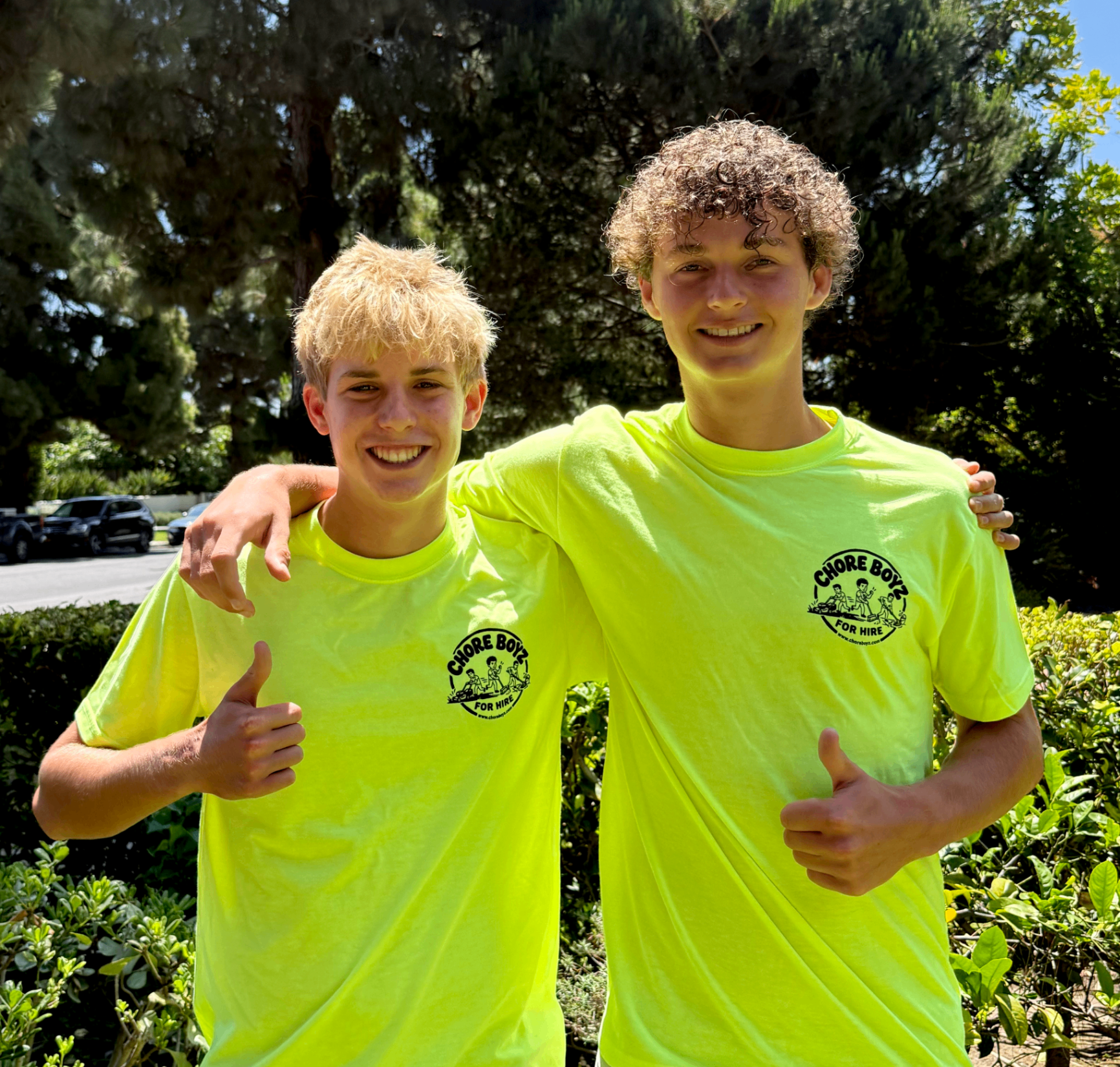 Two ChoreBoyz in neon shirts giving thumbs up